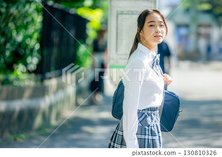 High school students waiting for the bus at the bus stop 130810326