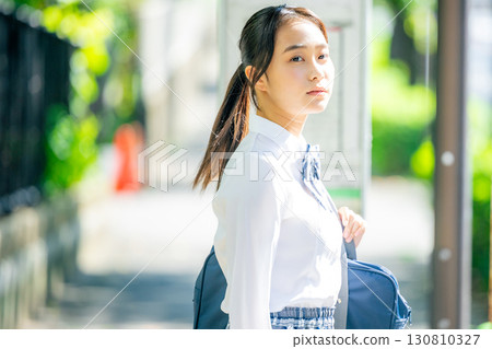 High school students waiting for the bus at the bus stop High school students waiting for the bus at the bus stop 130810327