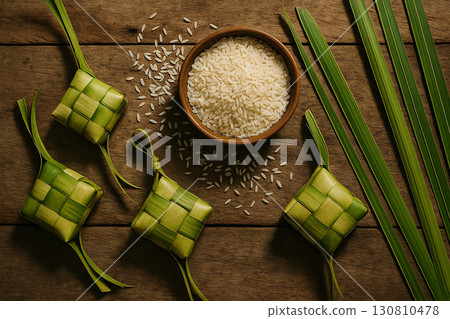 Ketupat displayed on green leaves with cultural Eid festive rustic setting. Eid celebration concept 130810478