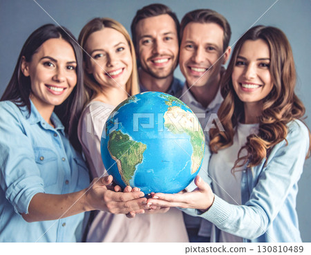 Smiling people gathered around a globe 130810489