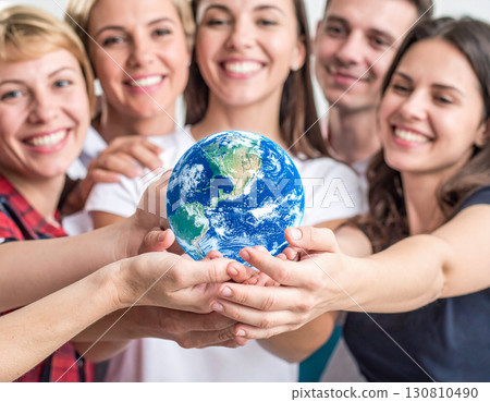 Smiling people gathered around a globe 130810490