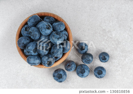 Fresh ripe blueberries in wooden bowl on light gray stone background closeup macro healthy food 130810856