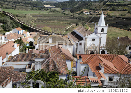 Church and rooftops in Obidos town, Portugal with scenic countryside view 130811122