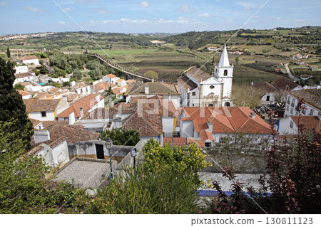 Church and rooftops in Obidos town, Portugal with scenic countryside view 130811123