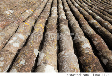 Roof tiles arranged in a wave pattern on an old building under natural sunlight Roof tiles arranged in a wave pattern on an old building under natural sunlight 130811128
