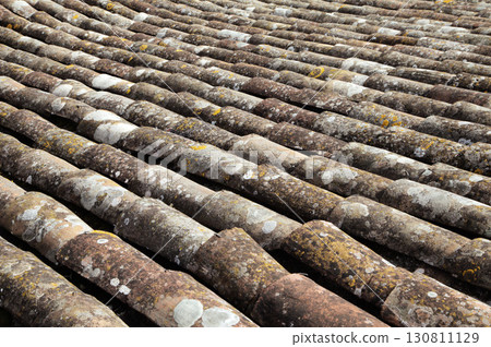 Roof tiles arranged in a wave pattern on an old building under natural sunlight Roof tiles arranged in a wave pattern on an old building under natural sunlight 130811129