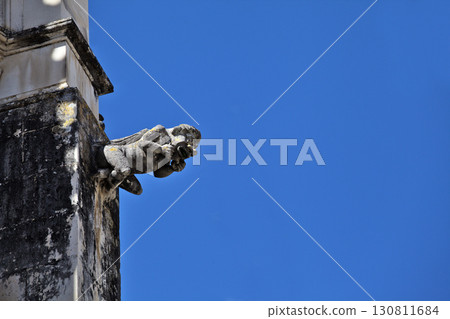 Gargoyle on Batalha monastery facade in Portugal on a clear day 130811684