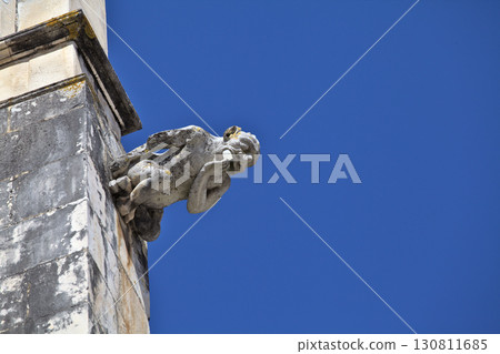 Gargoyle on Batalha monastery facade in Portugal on a clear day 130811685