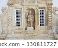 Stone sculpture of a figure with an umbrella on Coimbra University facade 130811727