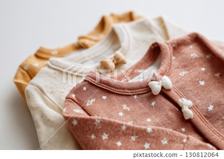 Baby onesie set on a light background. Fashion newborn clothes. Flat lay, top view. Baby kids soft clothing made from organic cotton. Infant trendy bodysuit natural colors, earth tones. Gender neutral 130812064