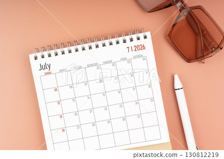 2026 July desk calendar with brown sunglasses. Directly above. Calendar and reminder concept. 130812219