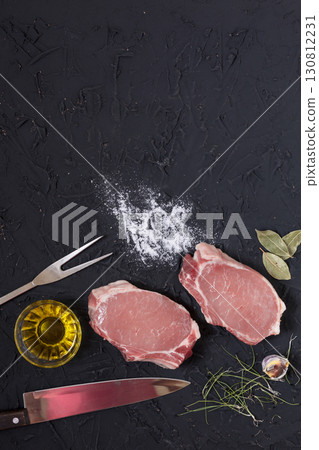 Rustic Raw Pork Chops with Spices, Herbs, and Kitchen Tools Rustic Raw Pork Chops with Spices, Herbs, and Kitchen Tools 130812231
