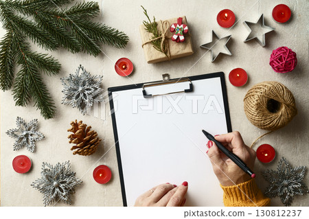 Woman writing a letter to Santa Claus at a festive table 130812237