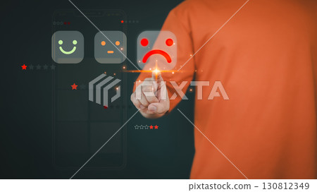 Customer hand touch a digital rating rating with sad face icon. Concept of poor customer experience, negative feedback, dissatisfaction, and low service quality in business or product reviews. 130812349