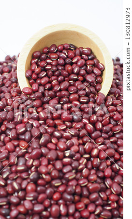 Adzuki beans spilling from wooden bowl on white background Adzuki beans spilling from wooden bowl on white background 130812973