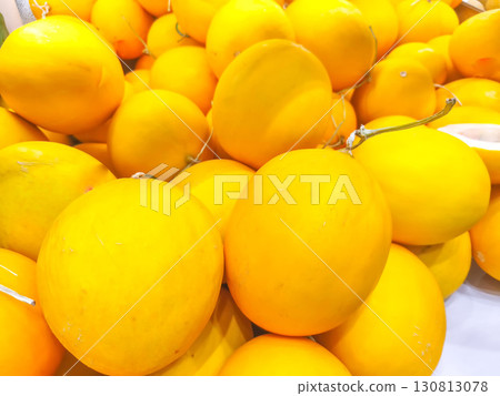 This is a close-up photo of various pickled fruits and vegetables, including mango, plums, and other items, stored in transparent plastic containers and displayed for sale. 130813078