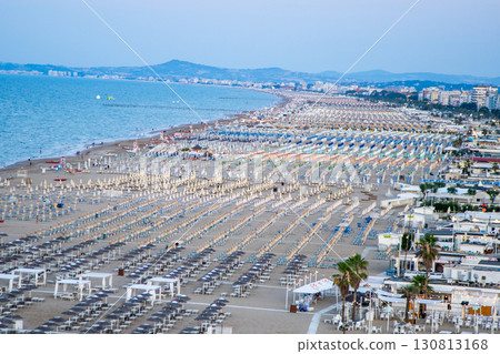 Wide sandy beach with sun loungers and umbrellas view from above. Evening on Rimini Italy coast resort 130813168