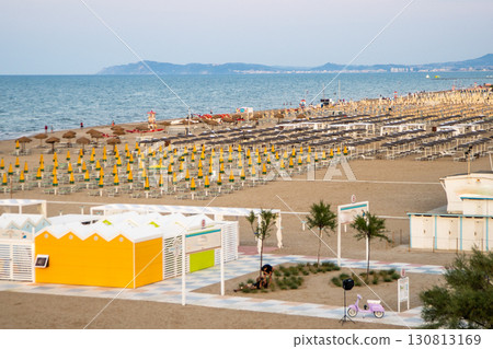 Wide sandy beach with sun loungers and umbrellas view from above. Evening on Rimini Italy coast resort 130813169