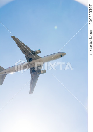 A passenger plane passing under the dazzling sun and blue sky near Heathrow Airport on the outskirts of London A passenger plane passing under the dazzling sun and blue sky near Heathrow Airport on the outskirts of London 130813597