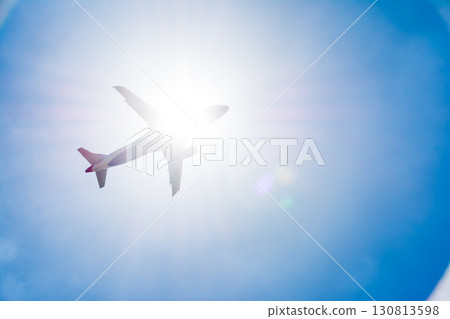 A passenger plane passing under the dazzling sun and blue sky near Heathrow Airport on the outskirts of London A passenger plane passing under the dazzling sun and blue sky near Heathrow Airport on the outskirts of London 130813598