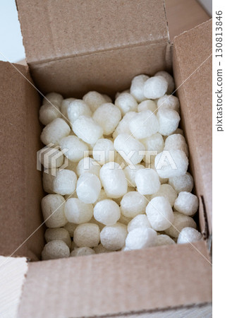 Open cardboard box close-up filled with eco-friendly corn based packing peanuts Sustainable packaging for safe and conscious shipping, promoting zero-waste 130813846