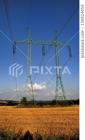 Green electricity pylons towering over czech wheat field in benesov district Green electricity pylons towering over czech wheat field in benesov district 130814058