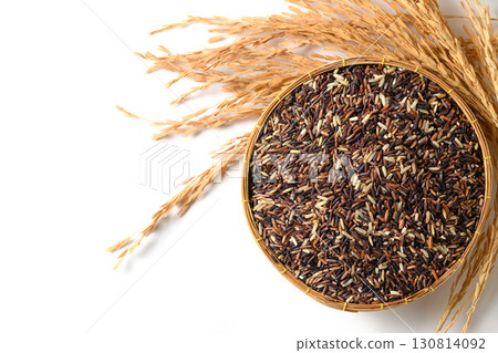 Top view of organic mixed rice grains in a bamboo basket with golden rice ears isolated on white background. Concept of healthy food, sustainable agriculture, and Asian cuisine ingredients. Top view of organic mixed rice grains in a bamboo basket with golden rice ears isolated on white background. Concept of healthy food, sustainable agriculture, and Asian cuisine ingredients. 130814092