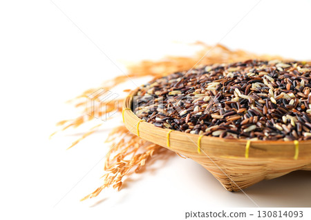 Close-up of organic mixed rice grains in a traditional bamboo basket with dried rice ears isolated on white background. Healthy natural food, agriculture product, and Asian cuisine ingredient concept. 130814093