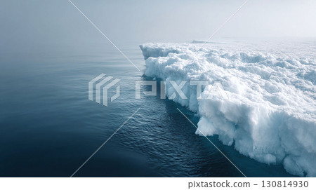 A stunning view of a colossal ice floe meeting the frigid sea, under a misty sky. Evokes climate change, isolation,  resilience. Ideal for conservation, travel, or abstract concepts. 130814930