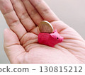 A miniature pink piggy bank with a coin rests in a human hand. Captures saving, finance, and investment concepts in a playful, accessible manner. 130815212