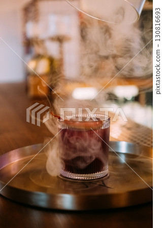 Serving drink. Scented cocktail. Lifting glass cloche from beverage on restaurant metal tray. Refreshing liquor with smoking aroma. Serving drink. Scented cocktail. Lifting glass cloche from beverage on restaurant metal tray. Refreshing liquor with smoking aroma. 130816693