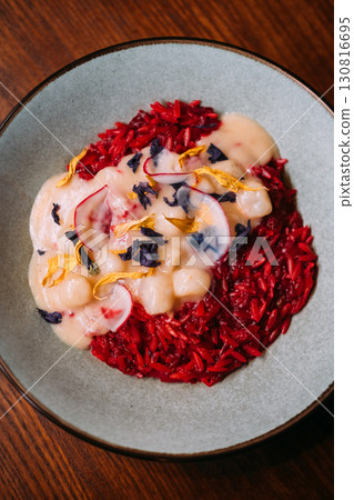 Spanish cuisine. Rice food. Tomato paella with stewed scallops in creamy sauce. Tasty launch decorated with dried herb spice on plate. Spanish cuisine. Rice food. Tomato paella with stewed scallops in creamy sauce. Tasty launch decorated with dried herb spice on plate. 130816695