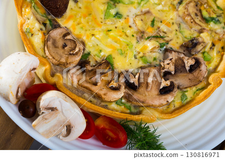 Delicious french quiche cooked with cheese and mushrooms 130816971
