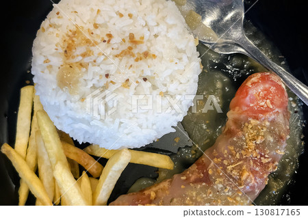 a sausage in the shape of a penis, covered in sauce, served on a plate with rice and French fries a sausage in the shape of a penis, covered in sauce, served on a plate with rice and French fries 130817165