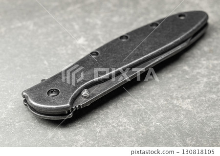 High detail image of a sleek black foldable pocket knife 130818105