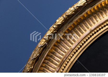 Close-up of a detailed, gilded round picture frame with intricate pattern 130818107