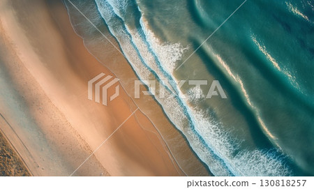 Aerial view beach gentle waves meeting sandy shore soft evening light 130818257