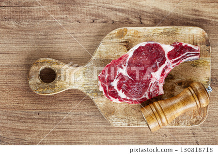 raw rib eye steak, cowboy steak, on a wooden chopping board, top view, no people, raw rib eye steak, cowboy steak, on a wooden chopping board, top view, no people, 130818718