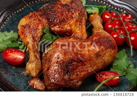 grilled fried chicken legs, served with fresh cherry tomatoes and herbs, on a plate, homemade, no people, 130818728