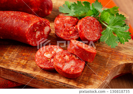 spicy Chorizo sausage, on a cutting board, on a wooden table. spicy Chorizo sausage, on a cutting board, on a wooden table. 130818735