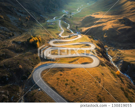 Aerial view of winding mountain road, river in alpine valley 130819055