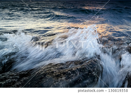 琵琶湖的白色波浪在岩石和日落之間流動 琵琶湖的白色波浪在岩石和日落之間流動 130819358