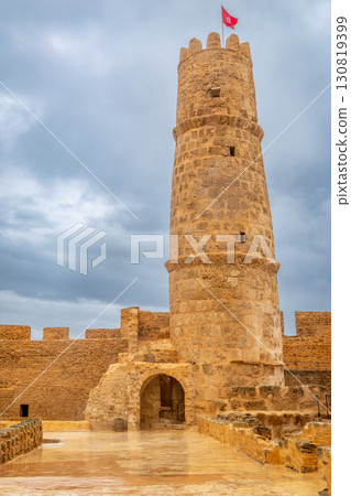 Inner yards and watch tower with tunisian flag on the top of Ribat of Monastir under cloudy skies, Monastir, Monastir Governorate, Tunisia Inner yards and watch tower with tunisian flag on the top of Ribat of Monastir under cloudy skies, Monastir, Monastir Governorate, Tunisia 130819399