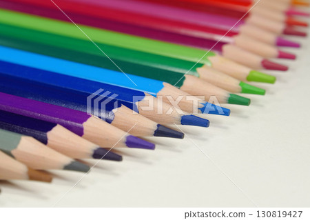 New wooden colored pencils of rainbow colors, perfectly sharpened, lie on table New wooden colored pencils of rainbow colors, perfectly sharpened, lie on table 130819427