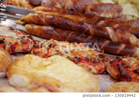 Bakery products on store counter. Pizza and other baked goods in bread shop Bakery products on store counter. Pizza and other baked goods in bread shop 130819442