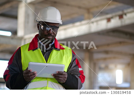 African american worker holds in hands tablet computer and looks at camera 130819458