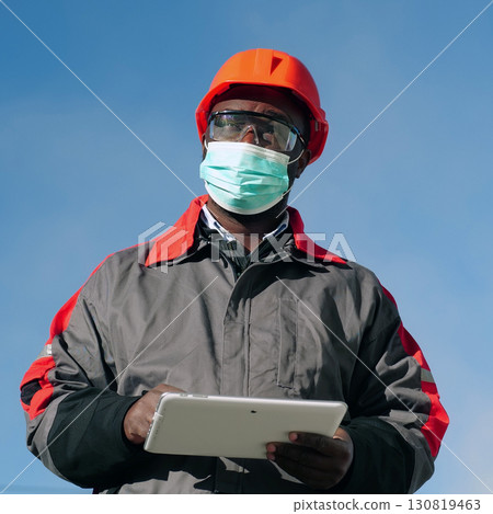 African american workman holds in hands white tablet computer African american workman holds in hands white tablet computer 130819463