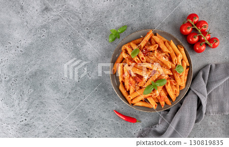 Italian pasta penne arrabiata with tomato sauce and chili pepper on blue background. Top view. Copy space 130819835