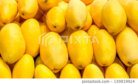 Vibrant, fresh, yellow mangoes neatly aligned offer a tropical treat, tips for healthy diets, radiating sunny warmth and sweet flavors from a fruitful market display. Healthy food and harvest concept Vibrant, fresh, yellow mangoes neatly aligned offer a tropical treat, tips for healthy diets, radiating sunny warmth and sweet flavors from a fruitful market display. Healthy food and harvest concept 130819924