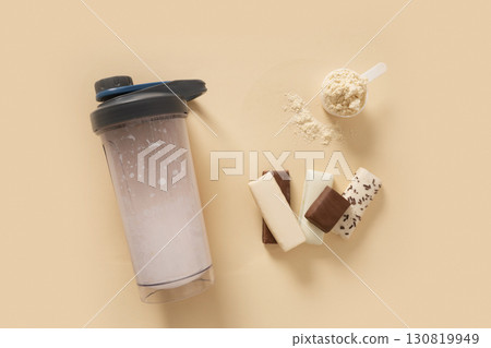 Whey protein shaker and powder in scoop on beige background. Close up. Whey protein shaker and powder in scoop on beige background. Close up. 130819949